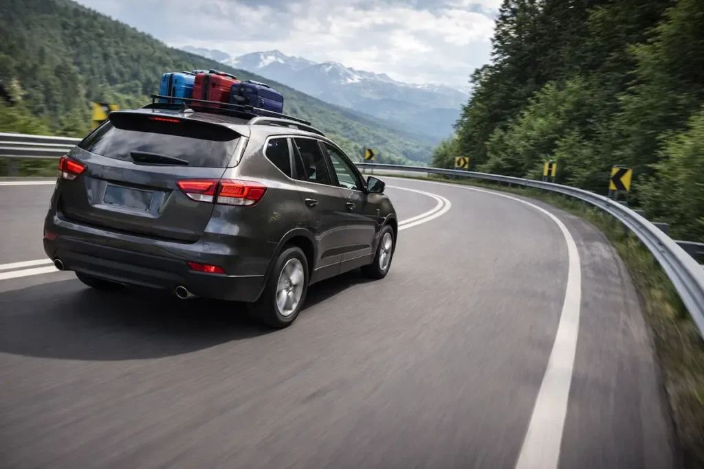 SUV carregado fazendo curva em estrada de montanha, demonstrando estabilidade e segurança com pneus reforçados Extra Load (XL)