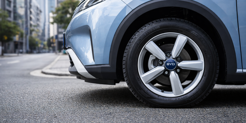 Roda e pneu de carro elétrico SUV estacionado em rua urbana